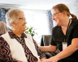 RÉSIDENCE AUBERGE DE LA RIVIÈRE JOLIETTE Une infirmière s'adressant à une femme âgée dans une résidence pour personnes âgées à Joliette.